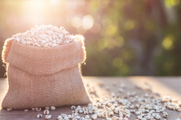 Ciérrese encima de granos del mijo del arroz o del mijo en pequeño saco en la tabla de madera