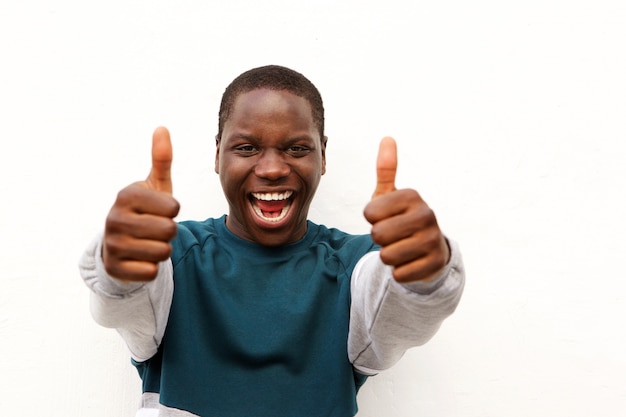 Ciérrese encima del hombre africano alegre que muestra los pulgares para arriba con dos manos en el fondo blanco