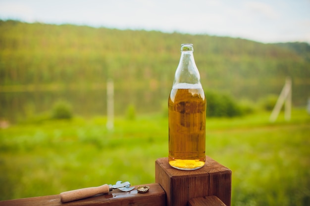 Ciérrese encima del hombre que bebe la cerveza del vidrio en el aire abierto cerca de la piscina. Concepto de alcohol y ocio.