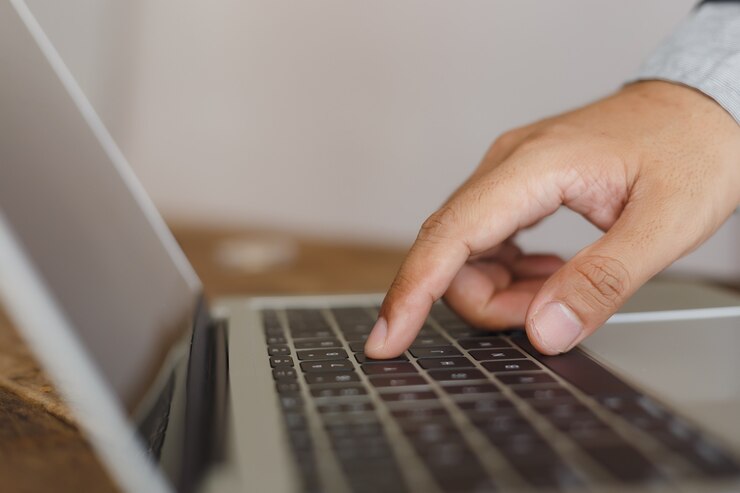 Foto ciérrese encima de la mano del ordenador portátil del ordenador de trabajo del hombre de negocios en la oficina. freelancer masculino escribiendo en la computadora.