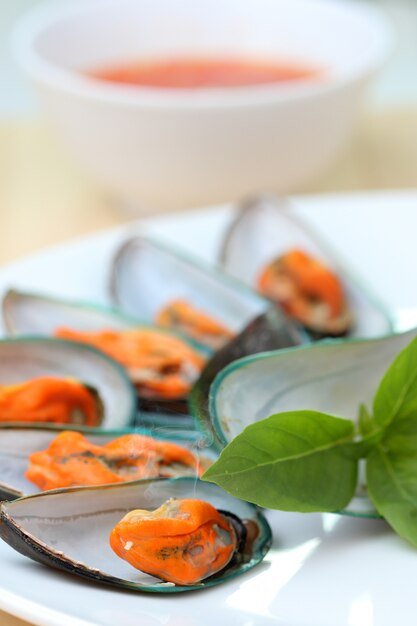 Ciérrese encima de los mejillones en el plato blanco.