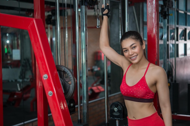 Ciérrese encima de la muchacha asiática hermosa del deporte en la pared del concepto del entrenamiento de la mujer del gymThailand love healthSlim