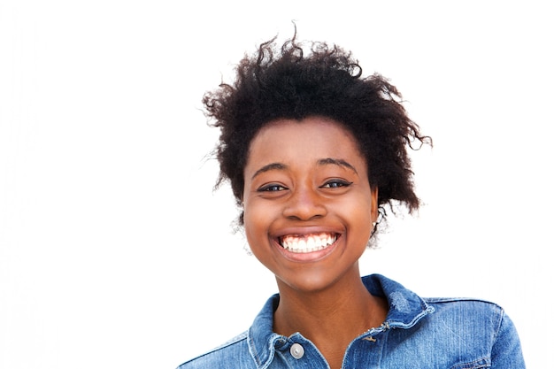 Ciérrese encima de la mujer afroamericana joven que sonríe contra el fondo blanco