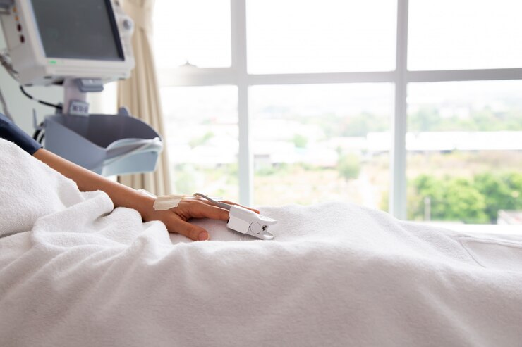 Ciérrese encima del paciente asiático de la mujer de la mano. Centrarse en la mano de un paciente en la sala del hospital.
