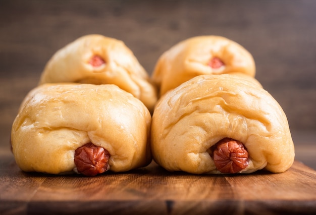 Ciérrese encima del pan de salchicha en la tarjeta de corte.