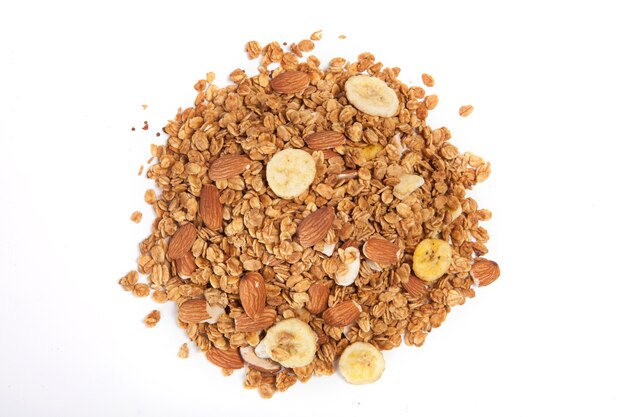 Ciérrese encima de pila Granola aislada en el fondo blanco.