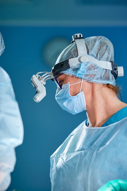 Ciérrese encima del retrato de la cirujana que lleva la máscara protectora y el sombrero durante la operación