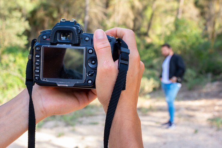Ciérrese encima del retrato del hombre del fotógrafo que toma la imagen con la cámara digital. Trabajo, concepto de sesión.