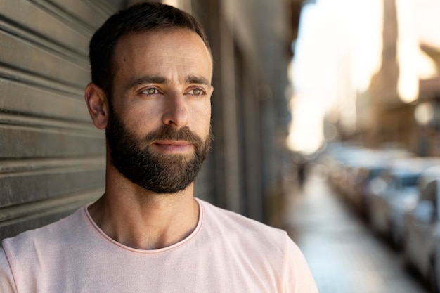 Ciérrese encima del retrato del hombre hispano apuesto pensativo con la barba elegante que mira lejos en la calle