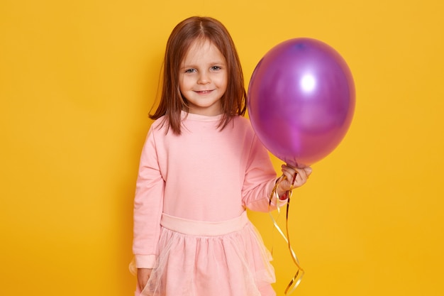 Ciérrese encima del retrato de la muchacha agradable dulce con el globo púrpura en manos.