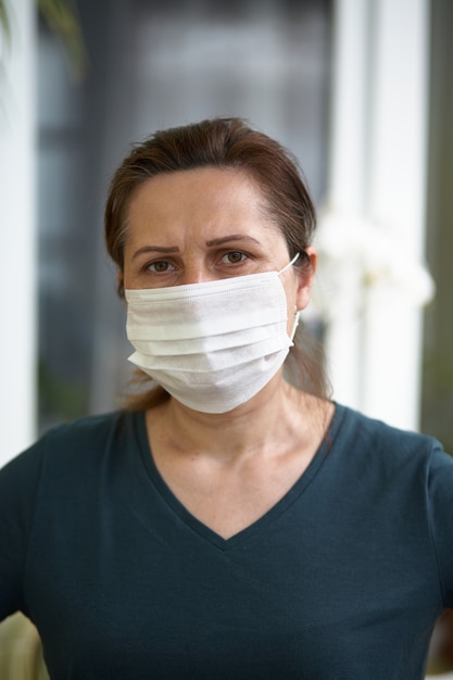 Ciérrese encima del retrato de la mujer que lleva la máscara quirúrgica debido a virus y a la contaminación atmosférica.