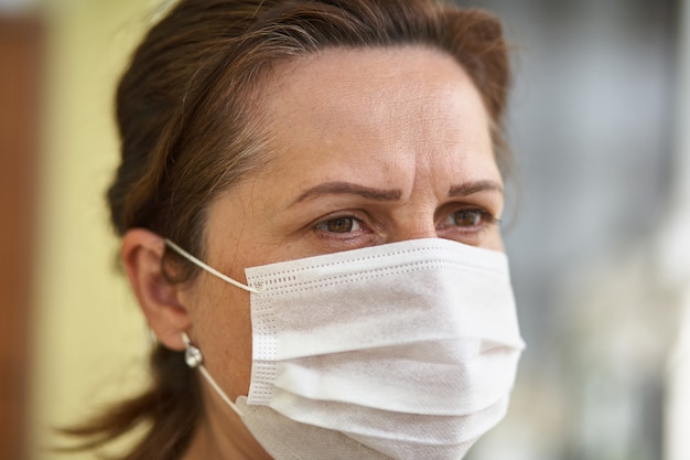 Ciérrese encima del retrato de la mujer que lleva la máscara quirúrgica debido a virus y a la contaminación atmosférica.