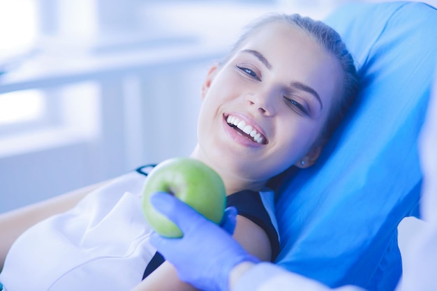 Ciérrese encima del retrato de la mujer sonriente sana con la manzana verde