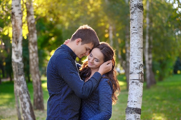 Ciérrese encima del retrato de la pareja joven atractiva en el amor al aire libre.