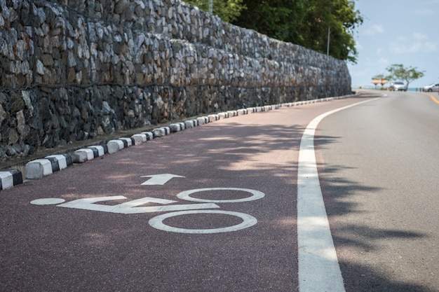 Ciérrese encima del signo o del icono blanco de la bicicleta en el camino