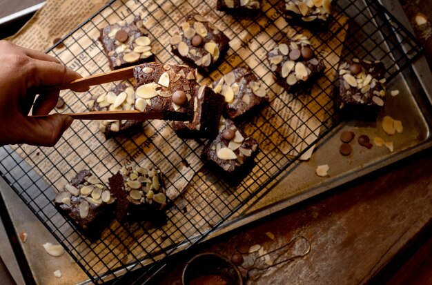 Ciérrese encima del tiro de la torta del brownie del chocolate con las nueces en un fondo rústico del metal