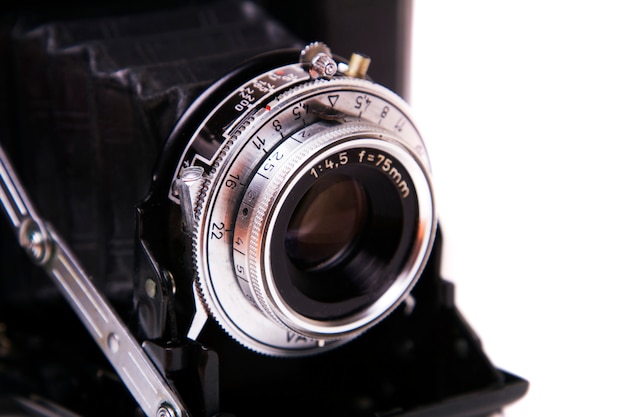 Ciérrese encima de vista de una cámara fotográfica del vintage retro aislada en un fondo blanco.