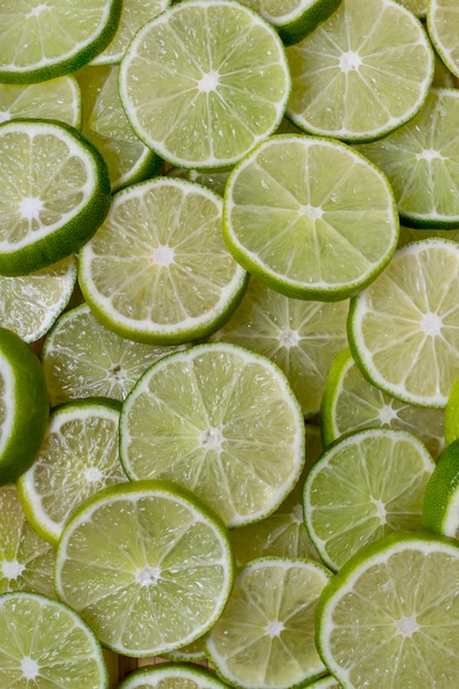 Ciérrese encima de vista de un manojo de rebanadas redondas de fruta de la cal aislada en un fondo blanco.