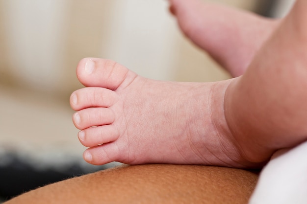 Ciérrese encima de vista de los pies recién nacidos de un bebé.