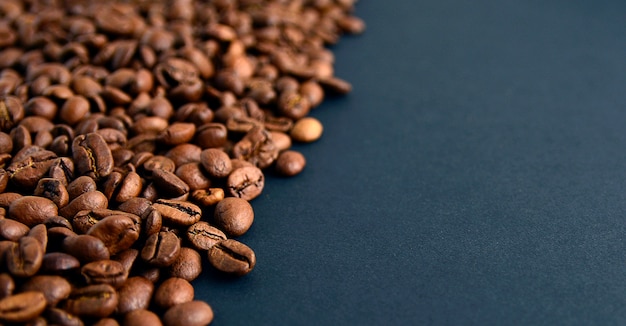 Ciérrese encima de la vista superior de los granos de café asados aislados en fondo negro