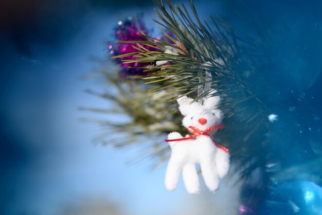 Ciervo blanco de juguete de Navidad en una rama