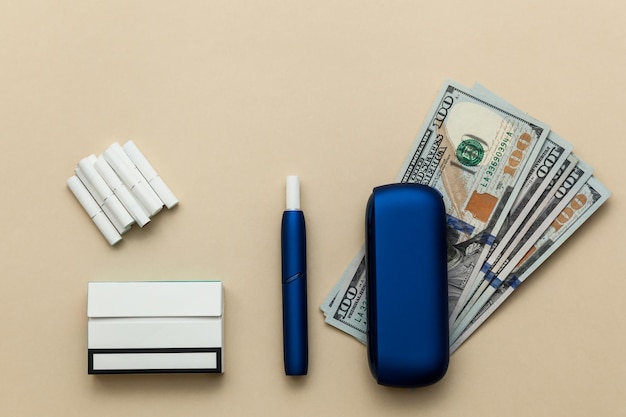 Cigarrillo electrónico IQOS azul con billetes de dólar en un fondo beige