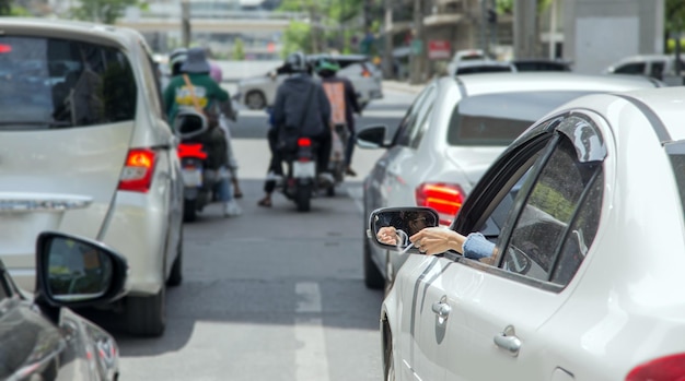 Cigarrillo en la mano del conductor en el auto con contaminación