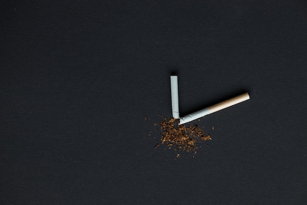 Cigarrillos rotos sobre un fondo negro Fumar mata
