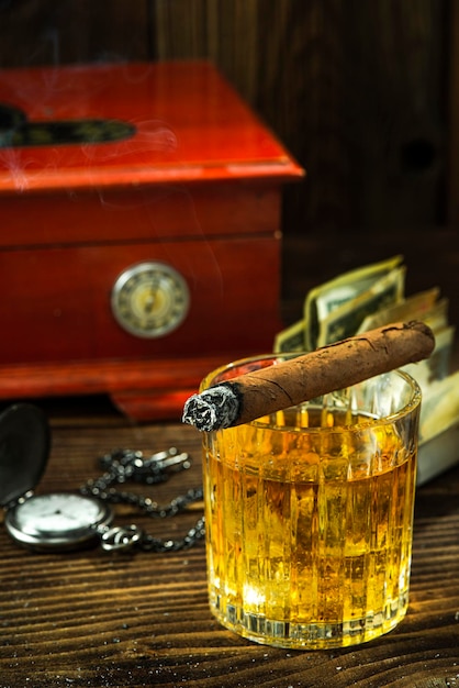 Cigarro cubano en vaso de whisky