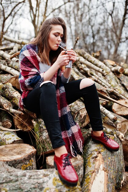 Cigarro de fumo de jovem na floresta