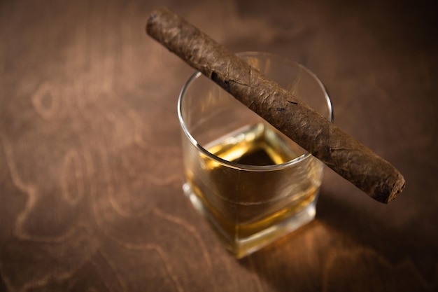 El cigarro se encuentra en un vaso con whisky