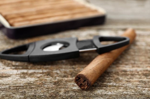 Cigarro envuelto en hoja de tabaco en primer plano de la mesa de madera
