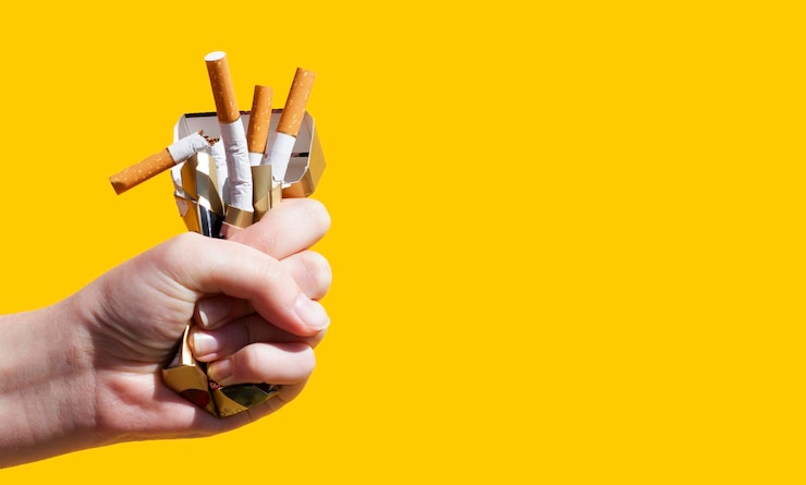 Foto cigarro na mão de uma mulher, cerrado em um punho sobre um fundo preto