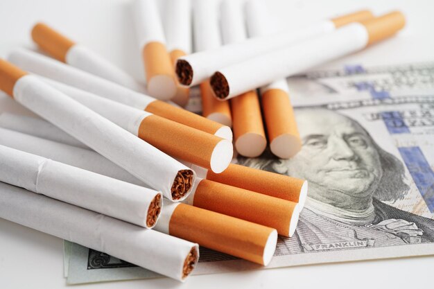Cigarro nas notas de dólar dos EUA custo de negociação comercialização e produção Não conceito de tabagismo
