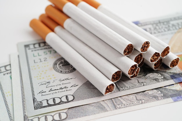 Cigarro nas notas de dólar dos EUA custo de negociação comercialização e produção Não conceito de tabagismo