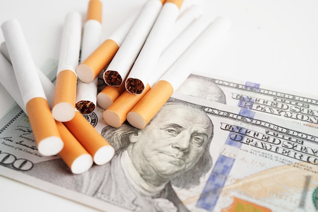 Cigarro nas notas de dólar dos EUA custo de negociação comercialização e produção Não conceito de tabagismo