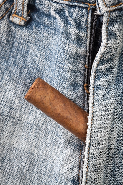 Cigarro puxa para fora do zíper de jeans