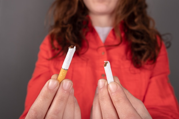 Cigarro quebrado na mão, pare de fumar.