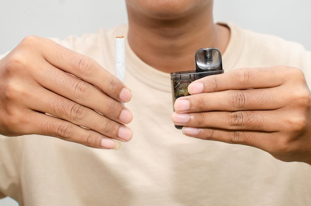 Cigarro vs conceito de cigarro eletrônico. homem segurando cigarro e vape.