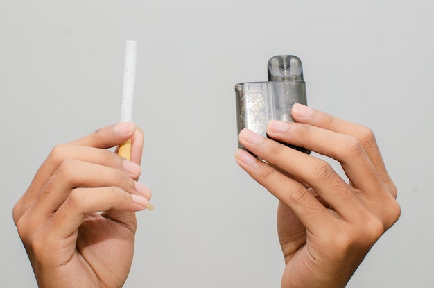 Cigarro vs conceito de cigarro eletrônico. homem segurando cigarro e vape.