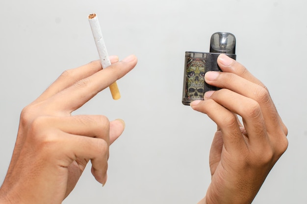 Cigarro vs conceito de cigarro eletrônico. homem segurando cigarro e vape.