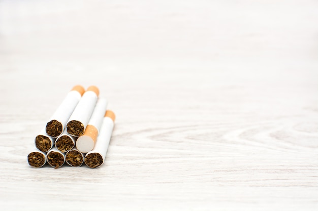 Foto cigarros na mesa de madeira branca copie o espaço