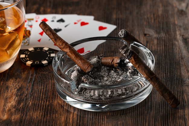 Cigarros y naipes en la mesa del casino