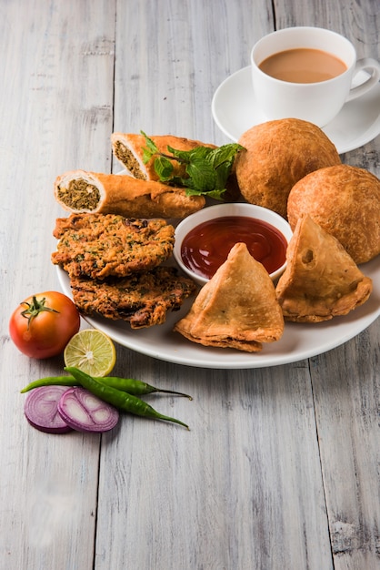 El cilantro o Kothimbir vada, Samosa, Kachori, Daal Vada son los bocadillos indios favoritos para la hora del té. enfoque selectivo