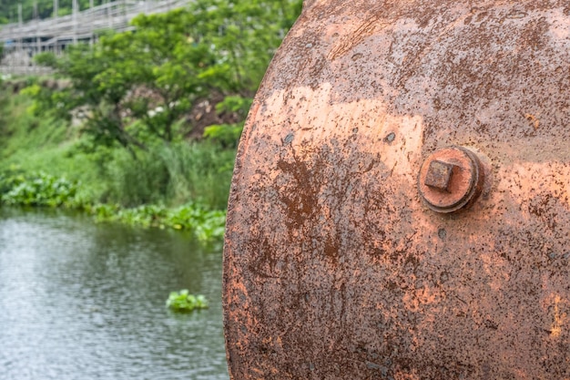 Cilindro de água rústico antigo ou tanque fechado no rio com espaço de cópia