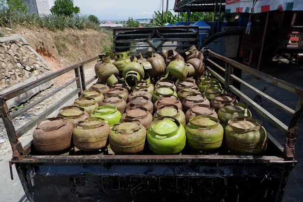 Foto cilindro de gas de 3 kg o botella de gas de melón en el proceso especial de distribución de gas de la camioneta pickup
