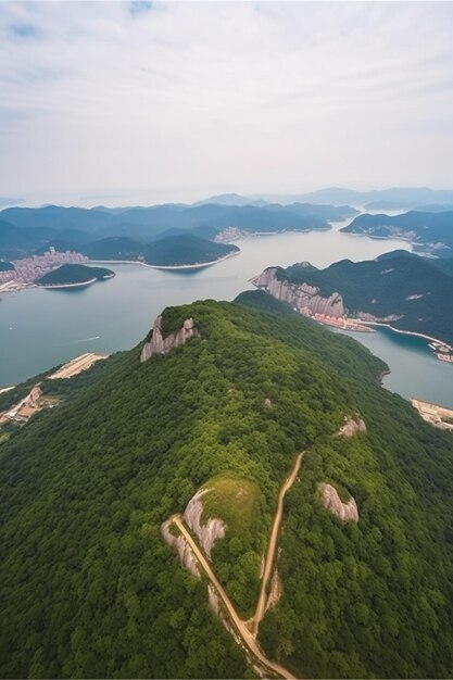 La cima de una montaña con una colina verde y un lago al fondo