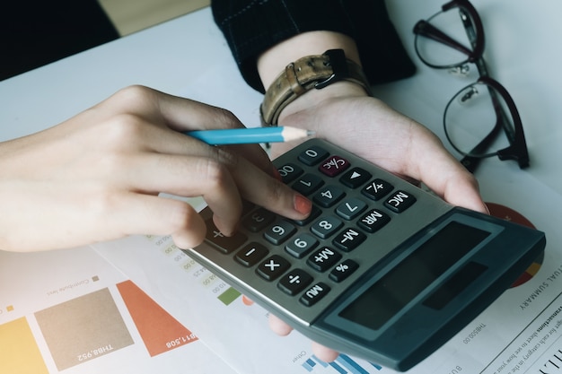 Cima, mulher negócio, usando, calculadora, para, faça, matemática, finanças, ligado, madeira, escrivaninha, em, escritório