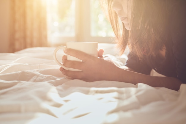 Cima, mulher, segurando, xícara café, cama, em, manhã, tempo