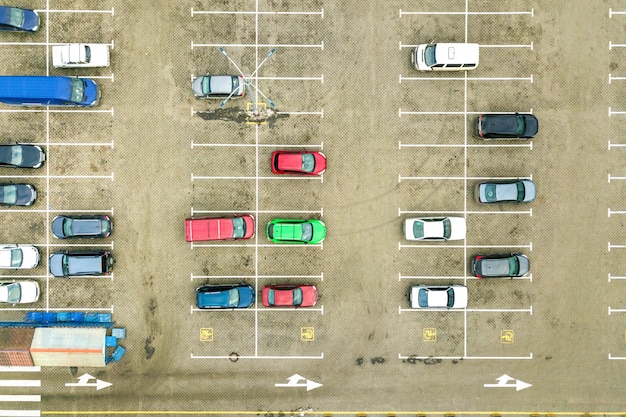 Cima para baixo vista aérea de muitos carros em um estacionamento de supermercado ou no mercado de revendedores de automóveis à venda.